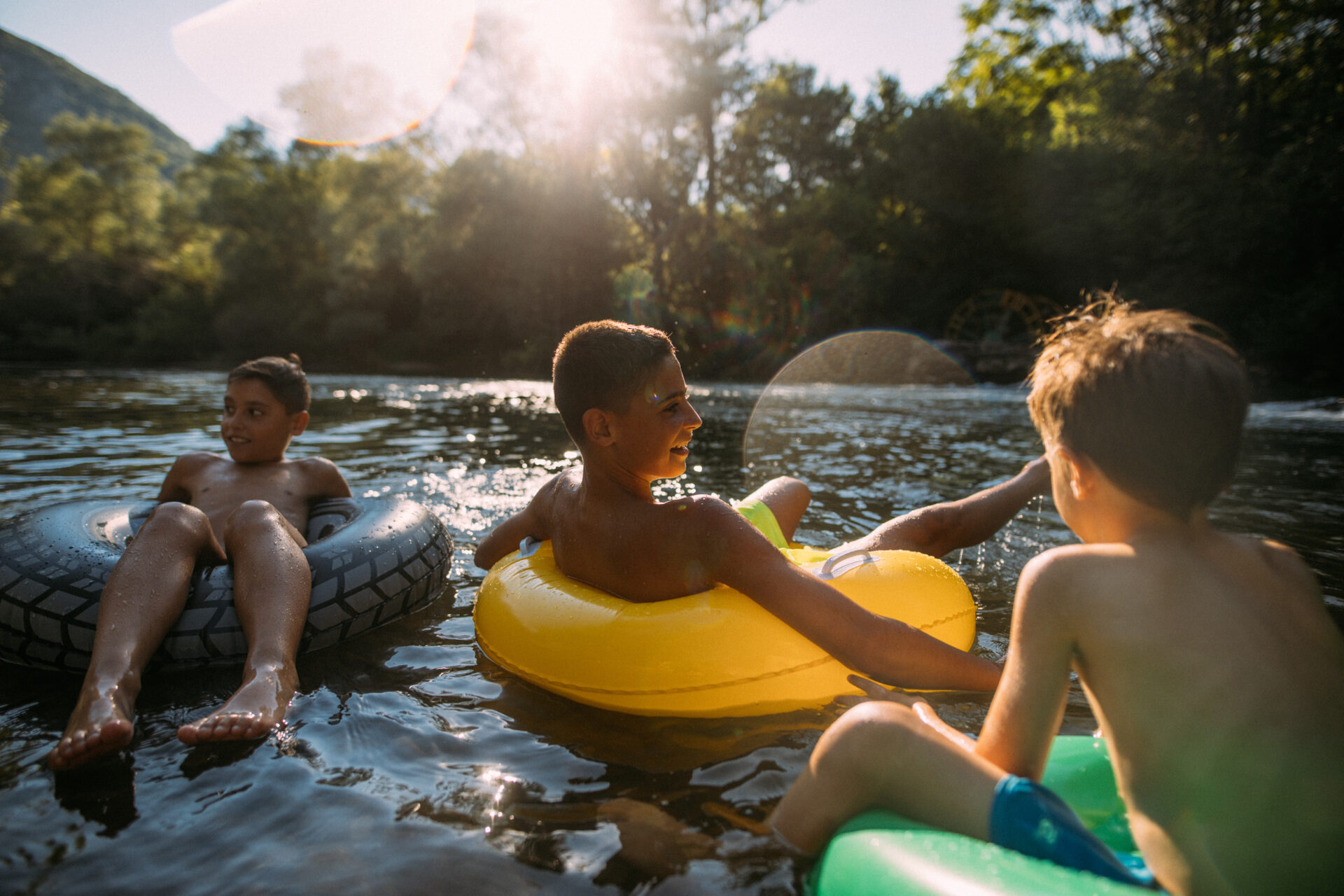 Kids floating down the river in New Braunfels on inflatable inner tubes