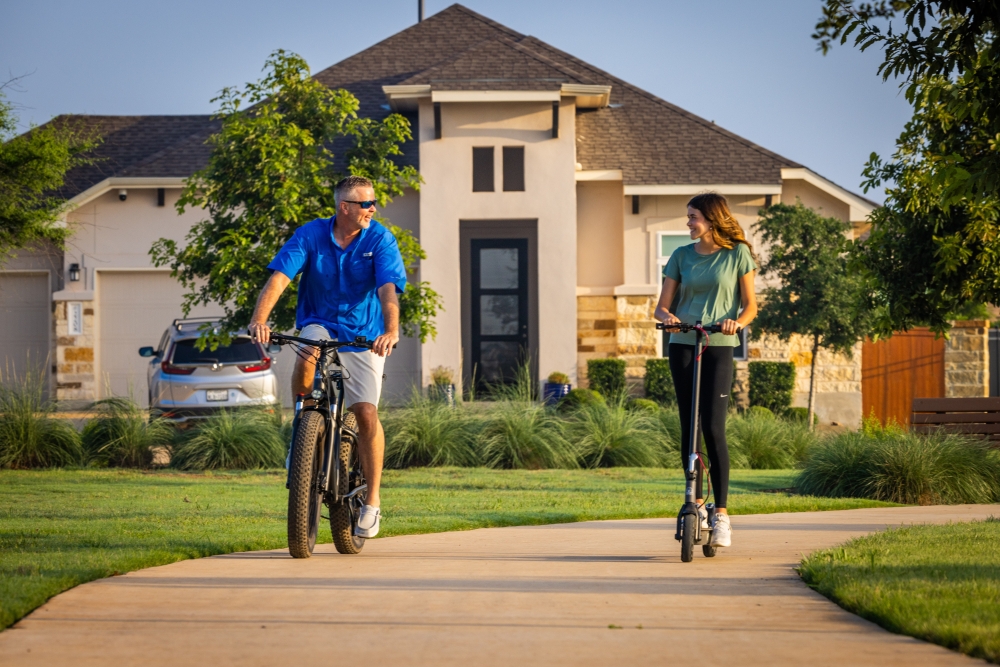 Empty nester couple riding bikes on community trails at Veramendi