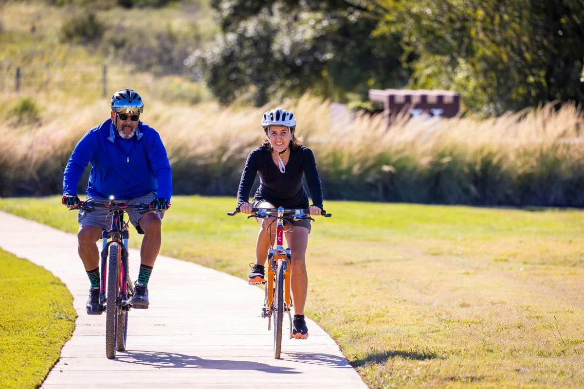 Two Veramendi residents cycling on the paved path in Veramendi.